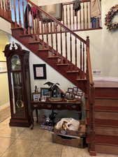 Stairs with tile patterned floors, visible vents, and baseboards