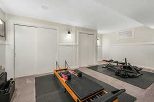 Workout area with a wainscoted wall and carpet floors