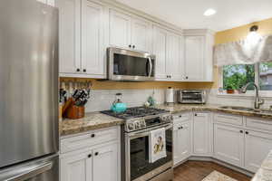 Kitchen with a sink, white cabinetry, appliances with stainless steel finishes, and a toaster