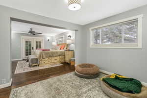 Bedroom with baseboards, visible vents, and wood finished floors