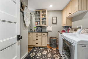 Laundry area with cabinet space, dark wood-style flooring, a sink, recessed lighting, and washer and clothes dryer