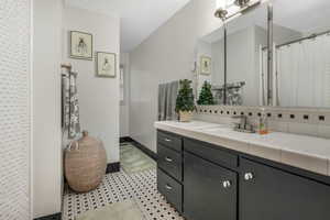 Bathroom with vanity and tasteful backsplash