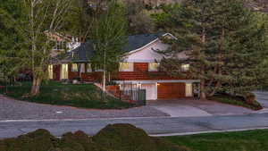 View of front of house with an attached garage, a front lawn, and concrete driveway