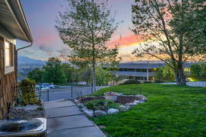 Yard at dusk featuring fence and cooling unit