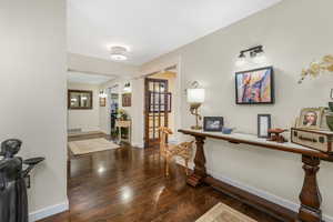 Foyer with baseboards, wood finished floors, and visible vents