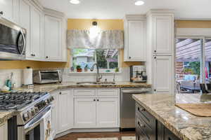 Kitchen featuring a sink, white cabinetry, a toaster, and stainless steel appliances