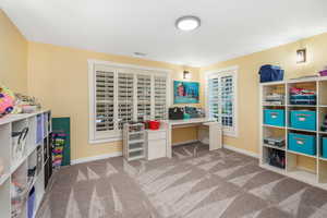 Carpeted office with baseboards and visible vents