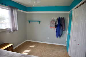 Unfurnished bedroom with baseboards, ceiling fan, and carpet