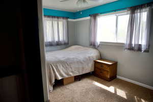 Carpeted bedroom featuring baseboards and ceiling fan