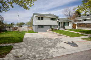 Tri-level home featuring fence and a front yard