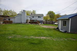 View of yard featuring a fenced backyard, an outdoor structure, and a deck