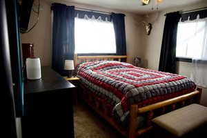 Carpeted bedroom featuring freestanding refrigerator
