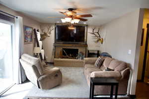 Living area featuring ceiling fan and a fireplace