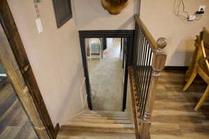 Stairway featuring baseboards and wood finished floors