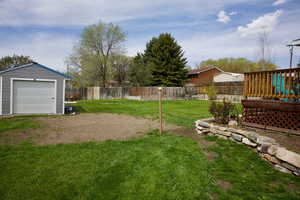View of yard with a fenced backyard and an outbuilding