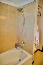 Bathroom featuring shower / bathtub combination and tile patterned flooring