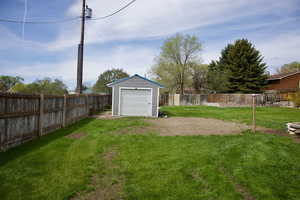 View of yard with a fenced backyard, a storage unit, and an outdoor structure