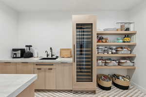 Bar with a sink, wet bar, and beverage cooler