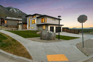 View of front of property with a garage, fence, a mountain view, and driveway