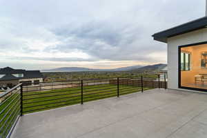 View of patio with a mountain view and a balcony