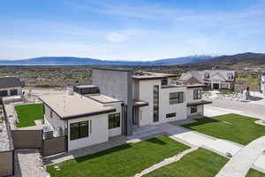 View of front of property with central air condition unit, fence, a mountain view, and stucco siding