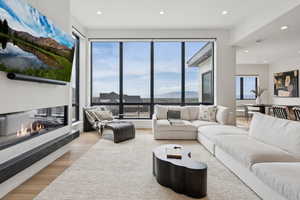 Living area featuring a glass covered fireplace, a mountain view, recessed lighting, and wood finished floors