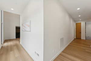 Hallway with visible vents, recessed lighting, and light wood-style floors