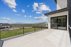 View of patio with a mountain view and a balcony