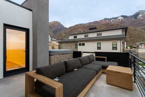 Balcony featuring a hot tub, an outdoor living space, and a mountain view