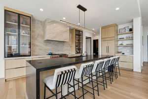 Kitchen featuring a sink, modern cabinets, light brown cabinetry, and tasteful backsplash