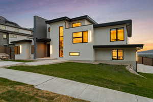 Contemporary home with a lawn and stucco siding