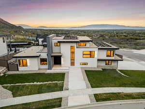 View of front of house featuring stucco siding, a front lawn, and a mountain view