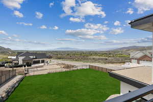View of yard with a mountain view and fence