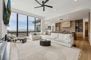 Living room featuring light wood-type flooring, a ceiling fan, and recessed lighting