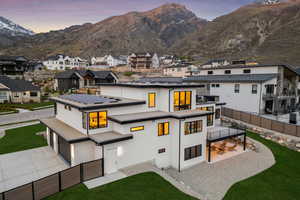 Rear view of property featuring a residential view, a garage, a mountain view, a fenced backyard, and stucco siding
