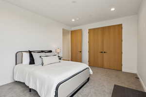 Bedroom with recessed lighting, baseboards, light colored carpet, and a closet