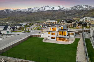 Back of property featuring stucco siding, a fenced backyard, a mountain view, and a residential view
