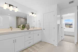 Bathroom with double vanity, water closet, and separate tub/shower.