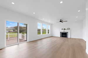 Living room featuring recessed lighting, a glass covered fireplace, ceiling fan, and hardwood finished floors