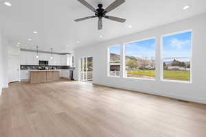 Living room featuring recessed lighting, a glass covered fireplace, ceiling fan, and hardwood finished floors