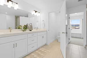 Bathroom with double vanity, water closet, and separate tub/shower.