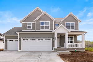 Craftsman-style house featuring covered porch, concrete driveway, roof with shingles, and 4 car garage