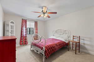 Carpeted bedroom with baseboards and ceiling fan