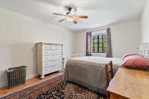 Bedroom with baseboards, a ceiling fan, and wood finished floors
