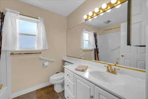 Bathroom with visible vents, tile patterned flooring, curtained shower, baseboards, and toilet