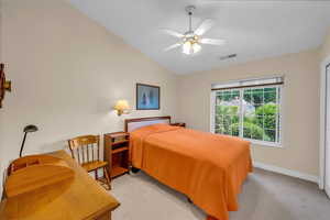 Bedroom featuring light carpet, a ceiling fan, baseboards, lofted ceiling, and visible vents