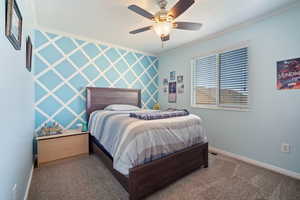 Bedroom with ornamental molding, a ceiling fan, carpet, and baseboards