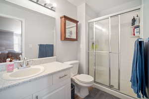 Full bath with toilet, a shower stall, and vanity