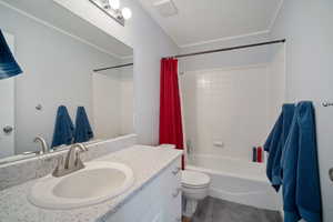 Bathroom with toilet, shower / bath combo with shower curtain, and vanity