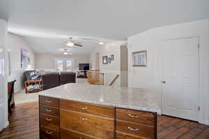 Kitchen featuring dark wood-style flooring, ceiling fan, and lofted ceiling